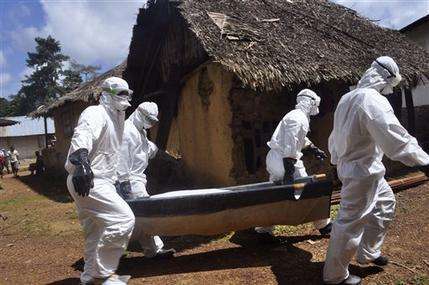 Health workers carry the body of a woman suspected of contracting the Ebola virus in Bomi county situated on the outskirts of Monrovia, Liberia, Monday, Oct. 20, 2014. Liberian President Ellen Johnson Sirleaf said Ebola has killed more than 2,000 people in her country and has brought it to "a standstill," noting that Liberia and two other badly hit countries were already weakened by years of war. (AP Photo/Abbas Dulleh)