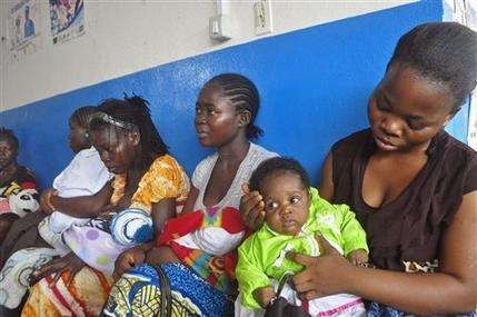 In this photo taken on Monday, Nov. 3, 2014, mothers wait inline for their children to be vaccinated by heath workers at the Pipeline Community Health Center, situated on the outskirts of Monrovia, Liberia. The Ebola outbreak has spawned a “silent killer,” experts say: hidden cases of malaria, pneumonia, typhoid and the like that are going untreated because people in the countries hardest hit by Ebola either cannot find an open clinic or are too afraid to go to one. (AP Photo/ Abbas Dulleh)