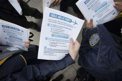 In this Oct. 24, 2014 file photo, members of the Brooklyn Borough President's office hand out fliers detailing the risks of Ebola outside The Gutter bowling alley in Brooklyn's Williamsburg neighborhood, in New York. Top medical experts studying the spread of Ebola say the public should expect more cases to emerge in the United States by year’s end as infected people arrive here from West Africa, including American doctors and nurses returning from the hot zone and people fleeing from the deadly disease. No one knows for sure how many infections will emerge in the U.S. or anywhere else, but scientists have made educated guesses based on data models that weigh hundreds of variables, including daily new infections in West Africa, airline traffic worldwide and transmission possibilities. (AP Photo/John Minchillo)