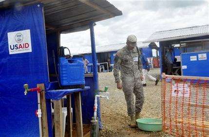 A member of the U.S army walks past a newly constructed Ebola treatment centre in Bongcounty, on the outskirts of Monrovia, Liberia, Tuesday Oct. 7, 2014. Liberia has been among the hardest hit nations at the center of the long outbreak, which has killed more than 3,000 people. As of Friday, there had been 3,834 confirmed Ebola cases and 2,069 deaths in Liberia, according to the World Health Organization. Forty-four percent of those cases were reported in the past three weeks, a signal that the infectious disease is spreading. (AP Photo/Abbas Duller)