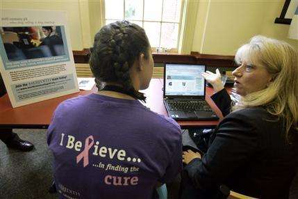 Anne McNeill, right, with IBM Corporate Community Relations, demonstrates the World Community Grid to sophomore Whitney Rains at Meredith College in Raleigh, N.C., in this Sept. 6, 2006 file photo. IBM has teamed with scientists at Scripps Research Institute in southern California in the fight against Ebola on a project that aims to combine the power of thousands of small computers, to each attack tiny pieces of the larger medical puzzle that might otherwise require a supercomputer to solve. (AP Photo/Gerry Broome)