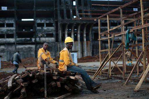  
              Construction workers take a break as they build an Ebola isolation and treatment center in front of a unfinished and abandoned government building in Monrovia, Liberia, Thursday, Sept. 25, 2014.  The center , due to open within two weeks, will add 200 beds to existing centers. The outbreak of Ebola has overwhelmed the weak health systems of some of the world's poorest countries: There aren't enough doctors and nurses or even clinics to treat the spiraling number of cases.(AP Photo/Jerome Delay)
             