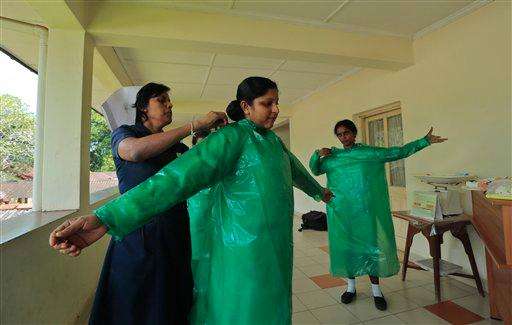  
              Sri Lankan health workers wear protective gear as they attend a preparedness program for Ebola at the Infectious Disease Hospital for fever in Colombo, Sri Lanka, Tuesday, Oct.28, 2014. Airports in Asia have stepped up their defenses: screening passengers who have travelled from affected countries, taking any with high temperature for observation and trying to keep contact them with for 21 days, the incubation period. According to the World Health Organization, more than 10,000 people have been infected with Ebola and nearly half of them have died. (AP Photo/Eranga Jayawardena)
             