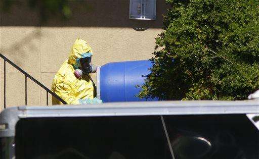  
              A hazardous material cleaner removes a blue barrel from the apartment in Dallas, Friday, Oct. 3, 2014, where Thomas Eric Duncan, the Ebola patient who traveled from Liberia to Dallas stayed last week. The family living there has been confined under armed guard while being monitored by health officials. (AP Photo/LM Otero)
             