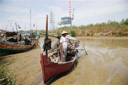  
              In this Oct. 18, 2014 photo, an Indonesian fisherman stand on his a boat in a river near power plants in Cirebon, Indonesia. The sprawling power station that hums and coughs along this coast in Indonesia is labeled as a Japanese contribution to the global fight against climate change. The plants promote new coal technology from Japanese companies, which is cleaner than old coal technology but still pollutes far more than solar, wind or natural gas. Villagers nearby also complain that the coal plant is damaging the local environment, and that stocks of fish, shrimp and green mussels have dwindled. (AP Photo/Achmad Ibrahim)
             