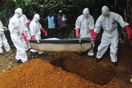  
              FILE : In this Saturday, Oct. 18, file photo a burial team in protective gear bury the body of a woman suspected to have died from Ebola virus in Monrovia, Liberia. The disease has ravaged a small part of Africa, but the international image of the whole continent is increasingly under siege, reinforcing some old stereotypes. (AP Photo/Abbas Dulleh, File)
             