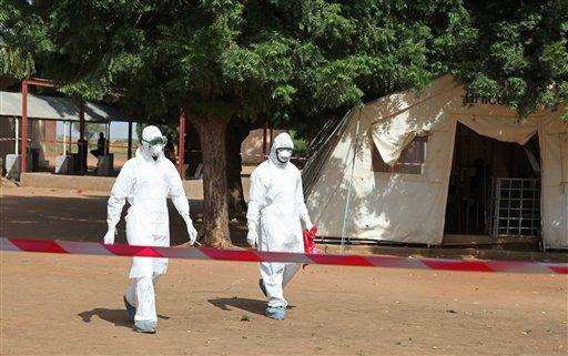  
              In this photo taken Saturday, Oct. 25, 2014, health workers walk towards an area used for Ebola quarantine after they worked with diseased Fanta Kone at a Ebola virus center in Kayes, Mali. After 2-year-old Fanta Kone’s father died in southern Guinea, the toddler’s grandmother took her from the forested hills where the Ebola outbreak first began months ago to bring her home to Mali. It wasn’t long, though, before the little girl started getting nosebleeds.  (AP Photo/Baba Ahmed)
             