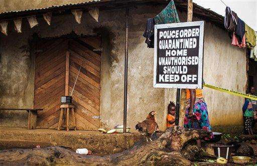  
              FILE - In this Wednesday, Oct. 22, 2014 file photo, a child stands near a sign advising of a quarantined home in an effort to combat the spread of the Ebola virus in Port Loko, Sierra Leone. More than 10,000 people have been infected with Ebola, according to figures released Saturday, Oct. 25, 2014 by the World Health Organization, as the outbreak continues to spread. Of those cases, 4,922 people have died. (AP Photo/ Michael Duff, File)
             