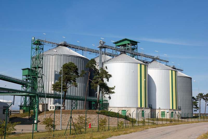 Multiple white biofuel tanks with green and yellow stripes. (Source: Aigars Reinholds/Thermo Fisher)