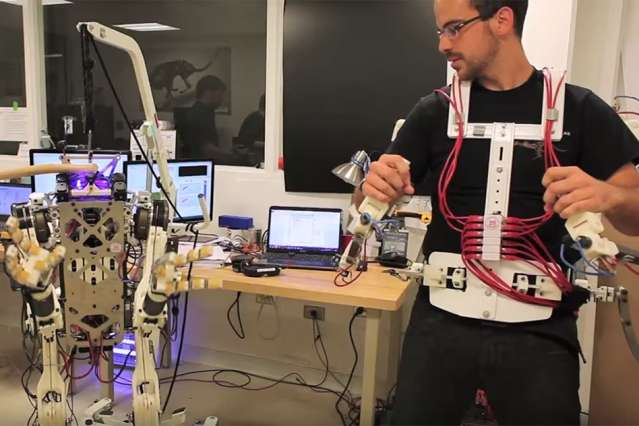 Ph.D. student Joao Ramos demonstrates the Balance Feedback Interface, a system that enables an operator to control the balance and movements of a robot, through an exoskeleton and motorized platform.  ( Photo: Melanie Gonick/MIT)