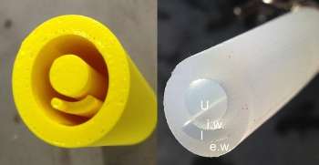 The yellow cast of an innovative new catheter design created by a 3D printer is shown on the left along with the finished prototype on the right. The markings indicate the urinary duct (U), the flexible inner wall (i.w.) between the urinary duct and the inflation channel (I) and the stiff exterior wall (e.w.). Pressurizing the narrow chamber deforms the main channel, dislodging biofilm so that it can be flushed from the tube. (Source: Duke University)